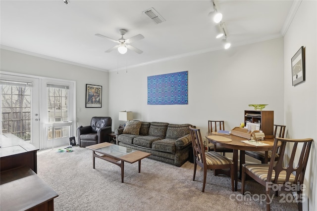 carpeted living area featuring a ceiling fan, crown molding, rail lighting, and visible vents