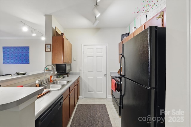 kitchen with light countertops, a sink, brown cabinetry, rail lighting, and black appliances