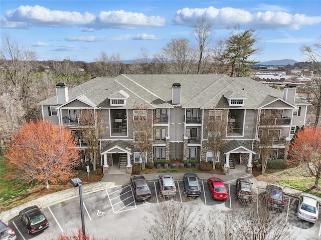 townhome / multi-family property featuring uncovered parking and a chimney