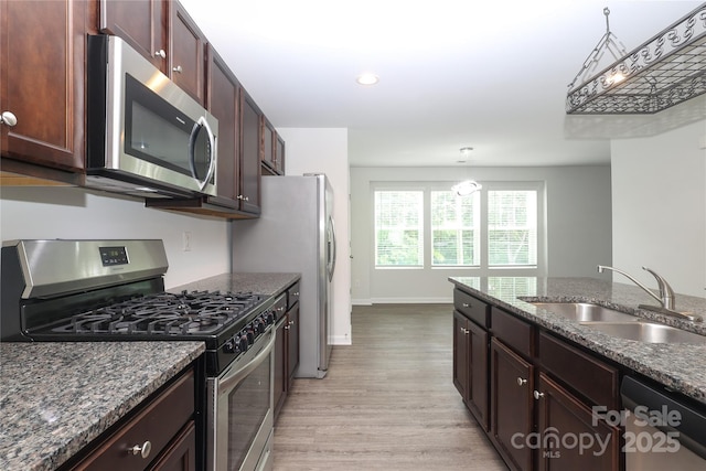 8232 Waxhaw Hwy, Waxhaw, NC 29173 - kitchen featuring stainless steel appliances, light wood finished floors, dark stone countertops, recessed lighting, and dark brown cabinets