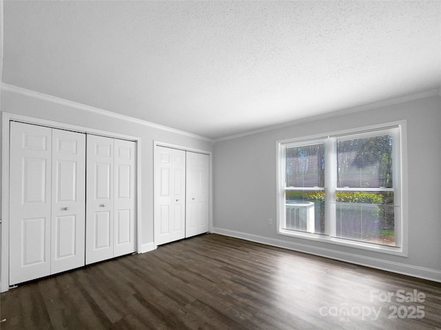 4936 Sardis Rd Unit B, Charlotte, NC 28270 - unfurnished bedroom with a textured ceiling, multiple closets, ornamental molding, and dark wood-style flooring