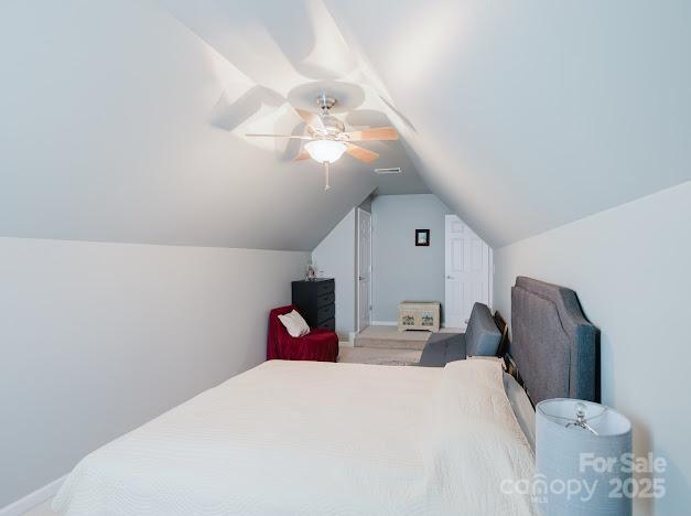6000 Pine Cone Ln, Monroe, NC 28110 - carpeted bedroom with visible vents, lofted ceiling, and ceiling fan
