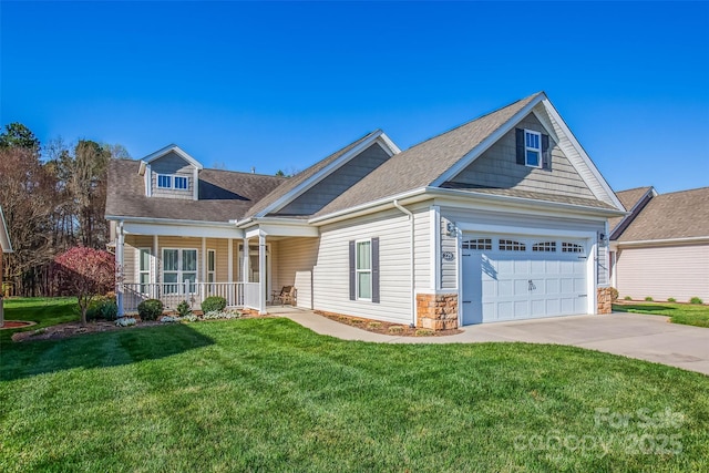 view of front facade with stone siding, driveway, a front lawn, covered porch, and a garage