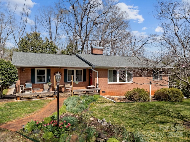 ranch-style house featuring brick siding, a chimney, a front lawn, and a porch