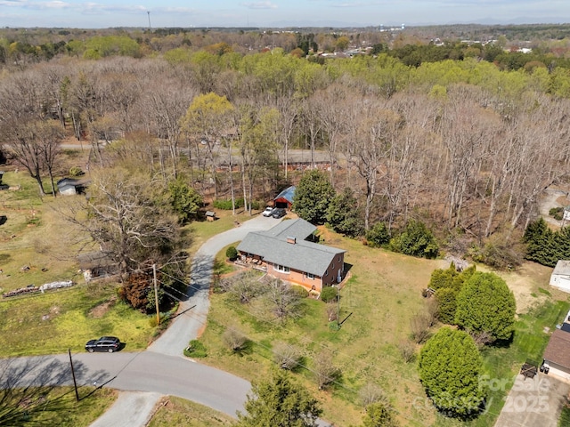 bird's eye view with a wooded view