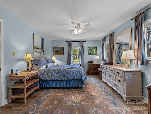 bedroom with baseboards, wood finished floors, and ceiling fan