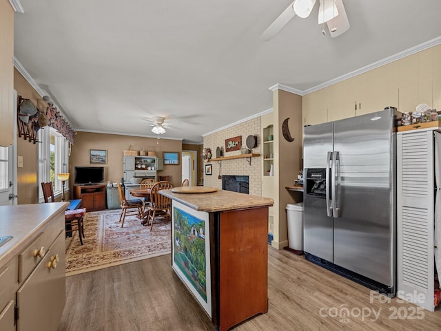 kitchen featuring light wood-type flooring, crown molding, ceiling fan, and stainless steel refrigerator with ice dispenser