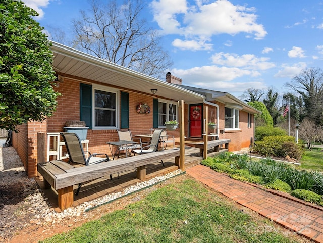 view of front of home featuring brick siding and a chimney