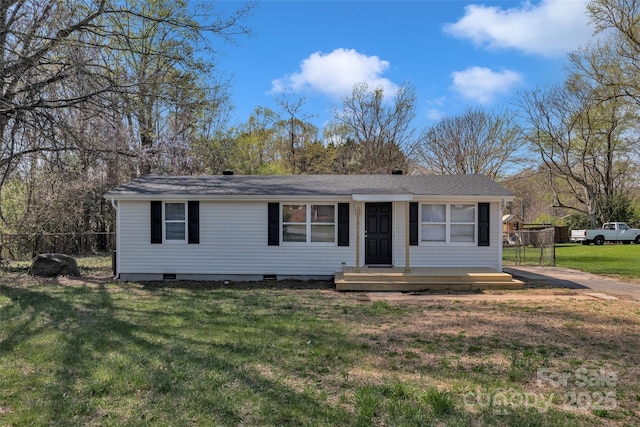 view of front of home with fence, a shingled roof, crawl space, and a front yard