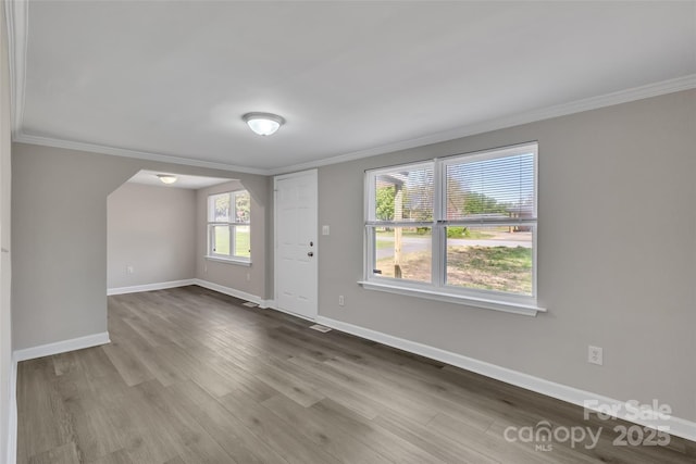 entryway featuring baseboards, ornamental molding, and wood finished floors
