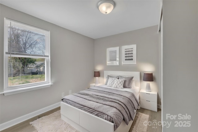 bedroom featuring baseboards and wood finished floors