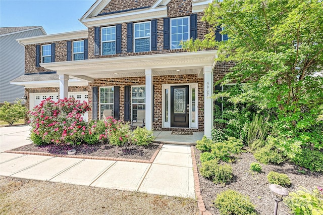 9937 Travertine Trl, Davidson, NC 28036 - view of front of home with brick siding, covered porch, and a garage