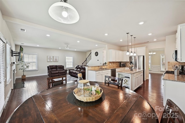 9937 Travertine Trl, Davidson, NC 28036 - dining area with dark wood finished floors, recessed lighting, a chandelier, and stairway