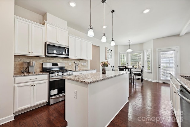 9937 Travertine Trl, Davidson, NC 28036 - kitchen featuring stainless steel appliances, backsplash, a kitchen island, white cabinetry, and dark wood-style flooring