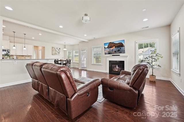 9937 Travertine Trl, Davidson, NC 28036 - living area with plenty of natural light, a fireplace with flush hearth, dark wood-type flooring, recessed lighting, and baseboards