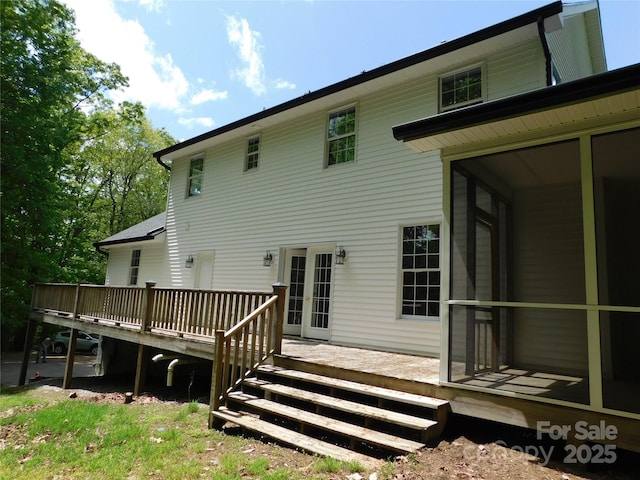 back of house with a wooden deck and a sunroom