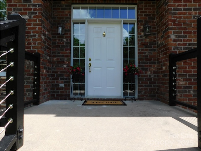 doorway to property with brick siding