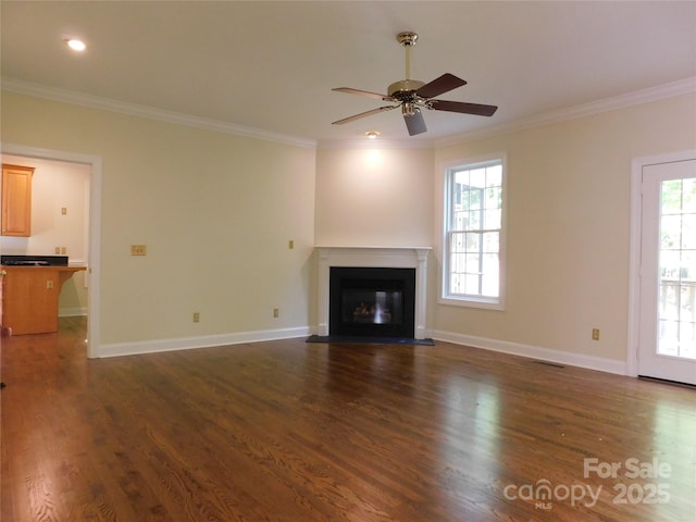 unfurnished living room with ornamental molding, dark wood-style flooring, a ceiling fan, and a fireplace with flush hearth