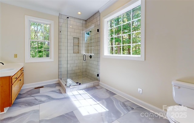 bathroom with baseboards, healthy amount of natural light, a shower stall, toilet, and recessed lighting