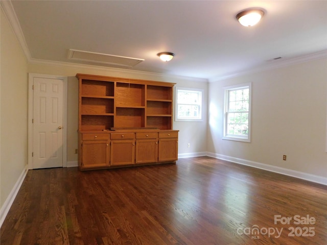 unfurnished living room featuring attic access, crown molding, dark wood finished floors, and baseboards
