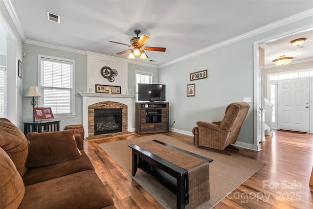 9113 Cinder Ln, Huntersville, NC 28078 - living area with visible vents, a fireplace, ceiling fan, ornamental molding, and wood finished floors