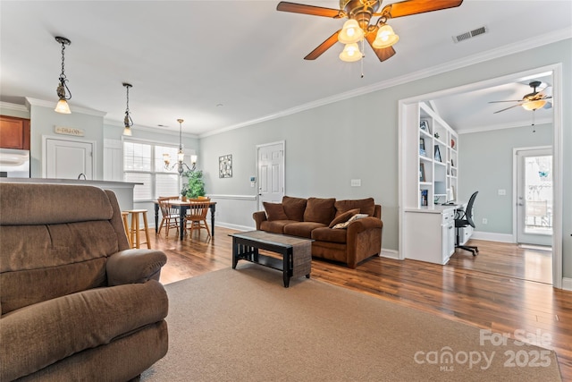9113 Cinder Ln, Huntersville, NC 28078 - living area with visible vents, baseboards, ornamental molding, wood finished floors, and ceiling fan with notable chandelier