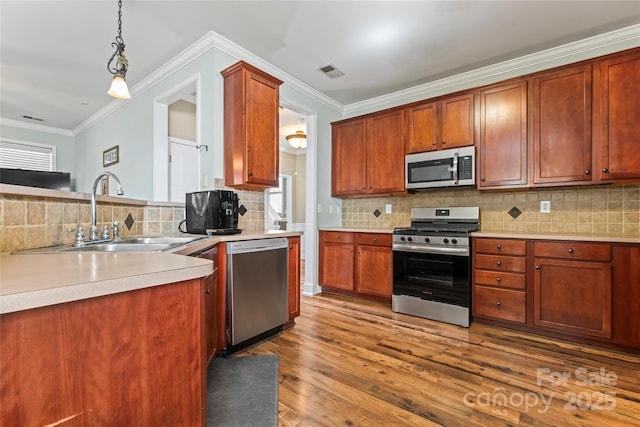 9113 Cinder Ln, Huntersville, NC 28078 - kitchen with a sink, wood finished floors, stainless steel appliances, visible vents, and ornamental molding