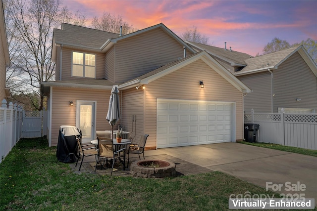 9113 Cinder Ln, Huntersville, NC 28078 - back of house with an attached garage, fence, concrete driveway, and an outdoor fire pit