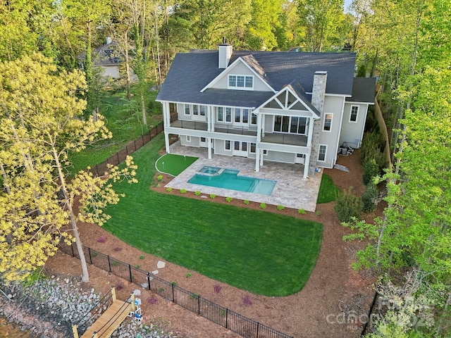 back of property featuring roof with shingles, a chimney, a patio area, a fenced backyard, and a yard