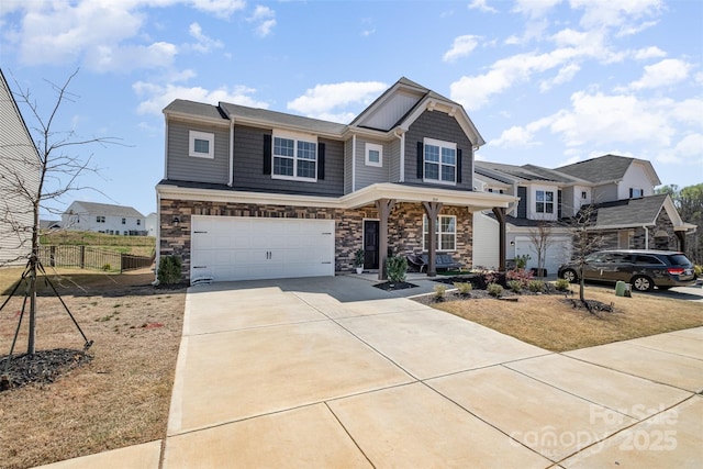 view of front facade featuring stone siding, concrete driveway, fence, and an attached garage