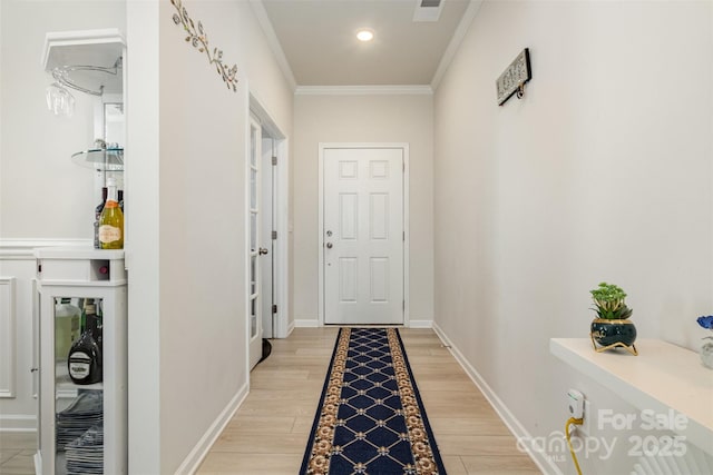 hall with visible vents, crown molding, baseboards, recessed lighting, and light wood-style floors