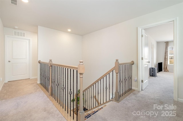 corridor featuring carpet flooring, an upstairs landing, and visible vents