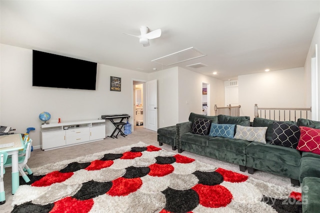 living area featuring visible vents, baseboards, ceiling fan, attic access, and light carpet