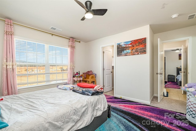 carpeted bedroom featuring baseboards, ceiling fan, and visible vents
