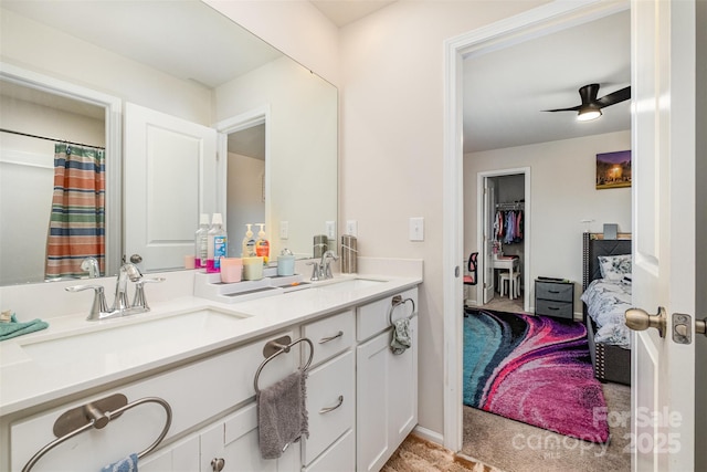 bathroom with double vanity, a sink, and a ceiling fan