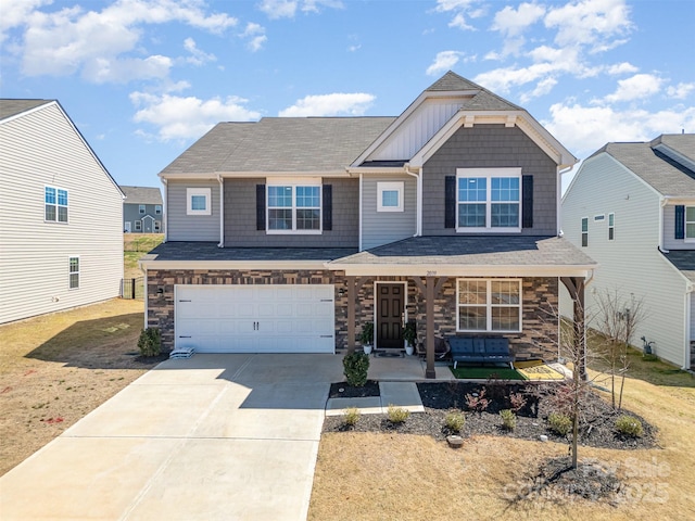 view of front of property featuring stone siding, an attached garage, driveway, covered porch, and a shingled roof
