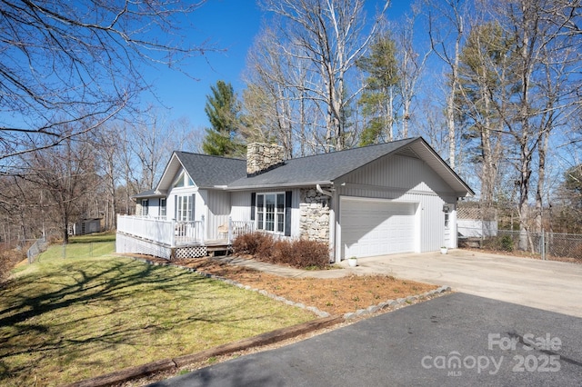 single story home with aphalt driveway, a deck, a front yard, a garage, and a chimney