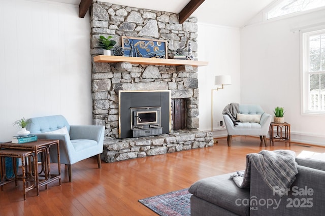living room with lofted ceiling with beams, visible vents, a fireplace, and wood-type flooring