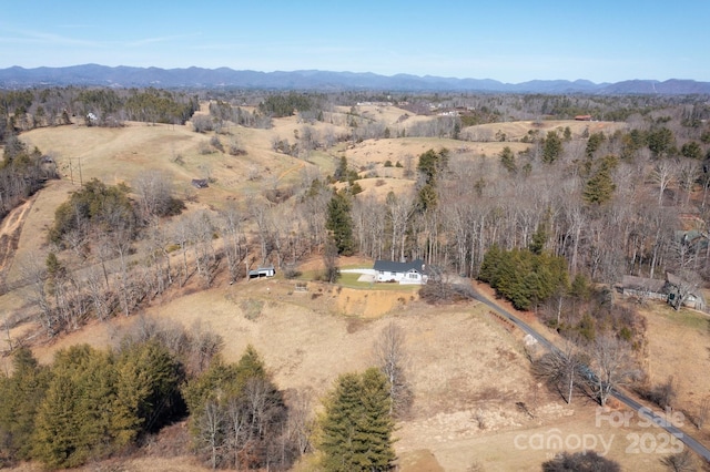 birds eye view of property with a wooded view and a mountain view