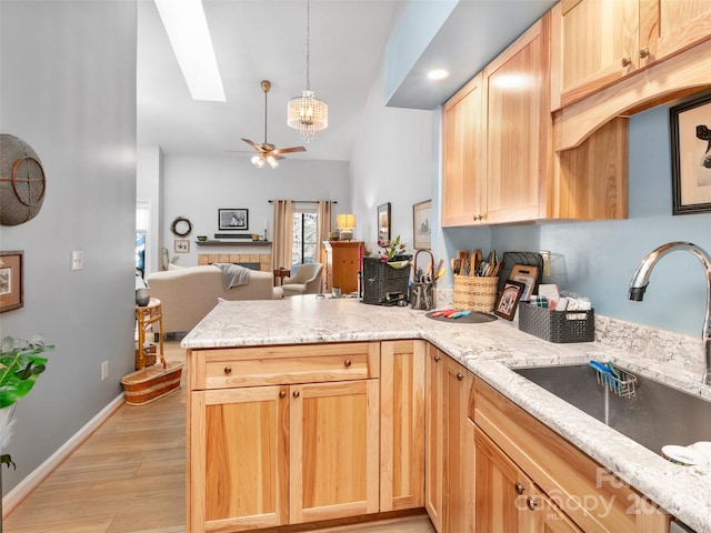 103 Cimarron Dr, Asheville, NC 28803 - kitchen featuring a sink, a ceiling fan, a skylight, a peninsula, and light brown cabinets