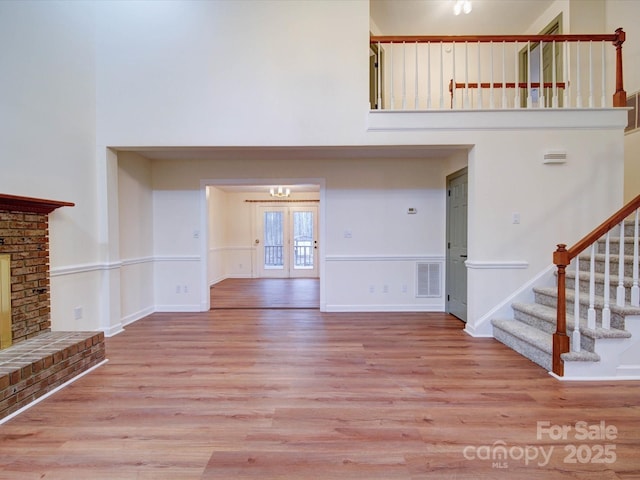 1312 Kensington Pl, Monroe, NC 28112 - unfurnished living room with stairs, visible vents, wood finished floors, and a towering ceiling