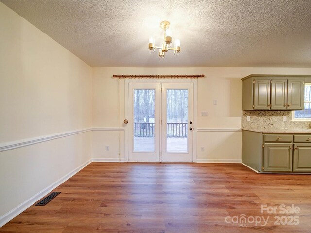 1312 Kensington Pl, Monroe, NC 28112 - unfurnished dining area with light wood-type flooring, baseboards, visible vents, and a notable chandelier