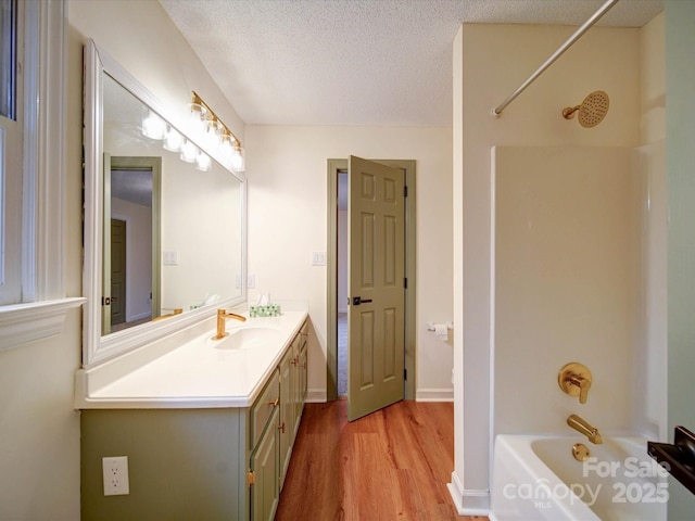 1312 Kensington Pl, Monroe, NC 28112 - bathroom with wood finished floors, vanity, bathing tub / shower combination, and a textured ceiling