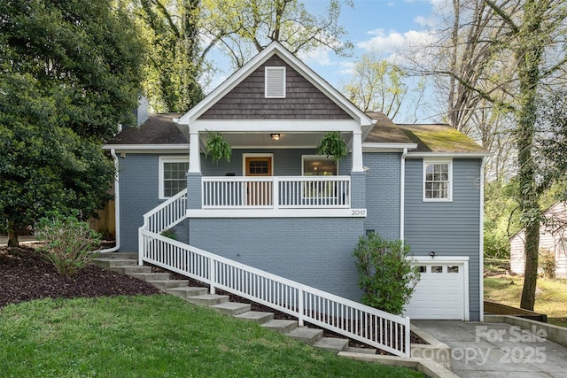 view of front facade with stairs, driveway, covered porch, an attached garage, and brick siding