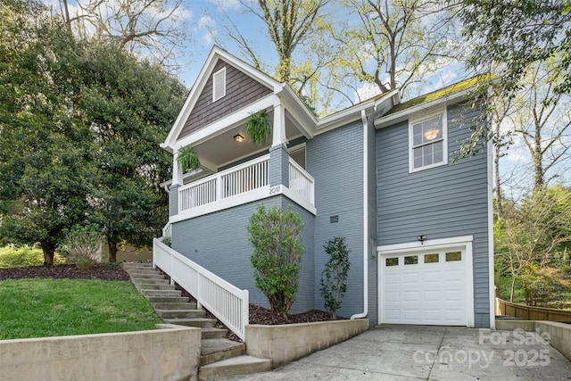 view of side of property with driveway, stairs, and an attached garage