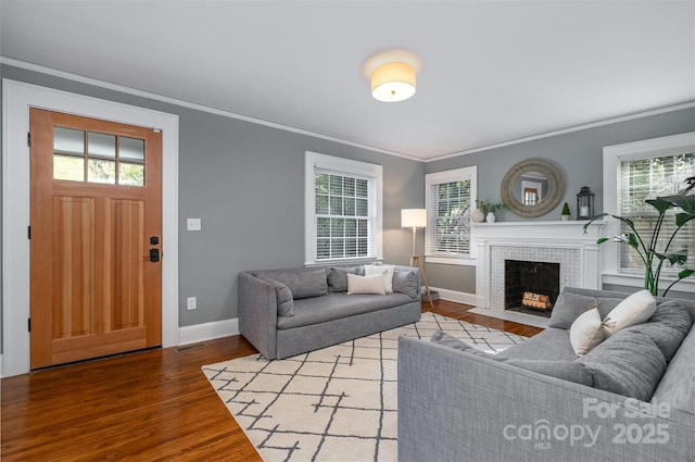 living area featuring visible vents, crown molding, baseboards, and wood finished floors