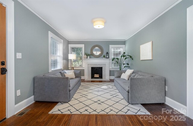 living room featuring wood finished floors, baseboards, and visible vents