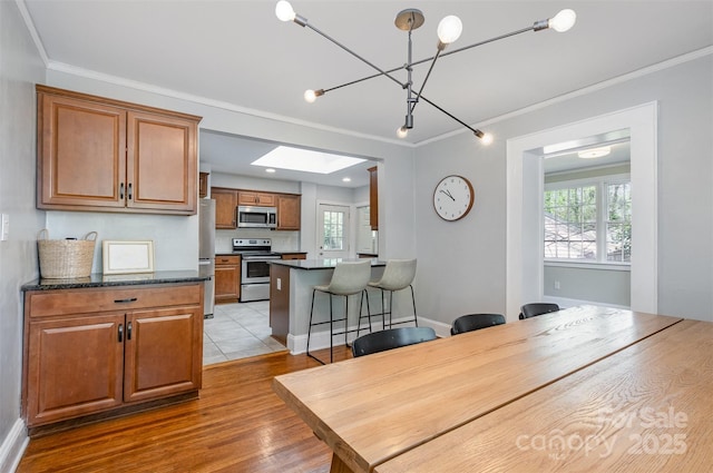 dining space with baseboards, ornamental molding, and wood finished floors
