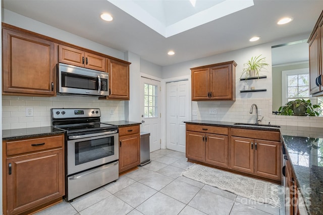 kitchen with plenty of natural light, open shelves, a sink, and stainless steel appliances