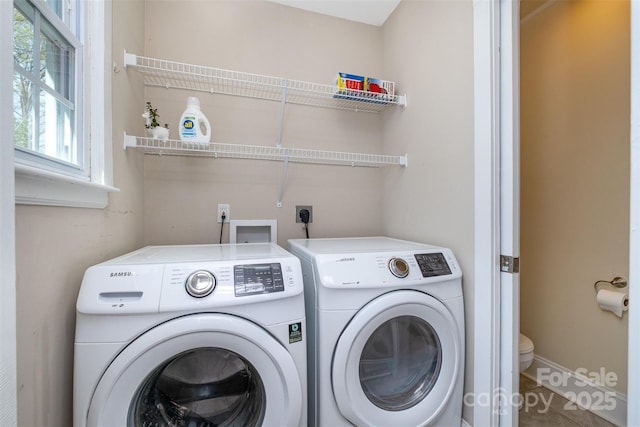 laundry room featuring baseboards, laundry area, and washer and clothes dryer